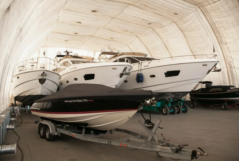 Technicians inspecting yacht systems in a covered marine storage facility